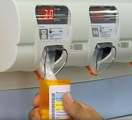 Soldier in pharmacy using tablet counting and dispensing machine