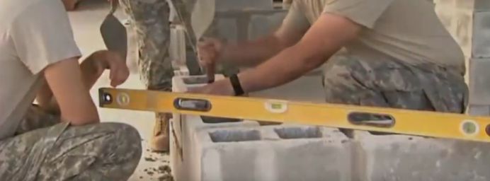 Soldiers building a concrete block structure